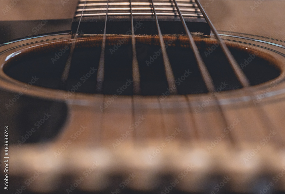 closeup of guitar sound hole looking down the strings of wood acoustic guitar of musician closeup of guitar sound hole looking down the strings of wood acoustic guitar of musician