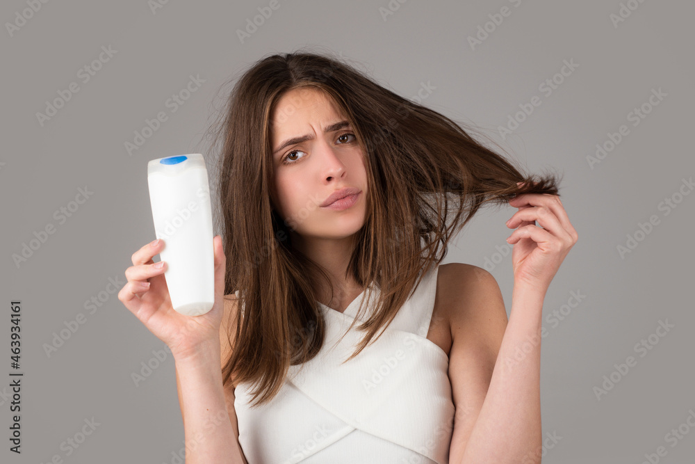 Young woman with bootle shampoo is very upset because of hair loss. Haircut and healthy haircare. Serious hair loss problem for health care shampoo. Young woman with bootle shampoo is very upset because of hair loss. Haircut and healthy haircare. Serious hair loss problem for health care shampoo.