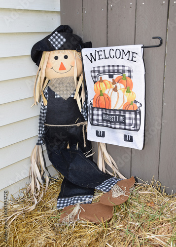 scarecrow sitting on a bale of hay