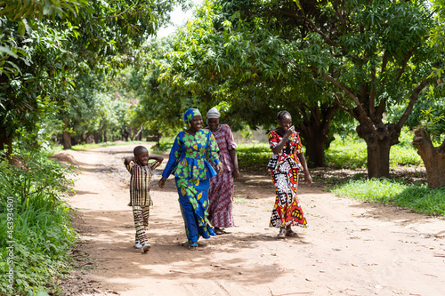 Canvastavla A group of happy black African villagers strolling on a dirt road in a West Afri
