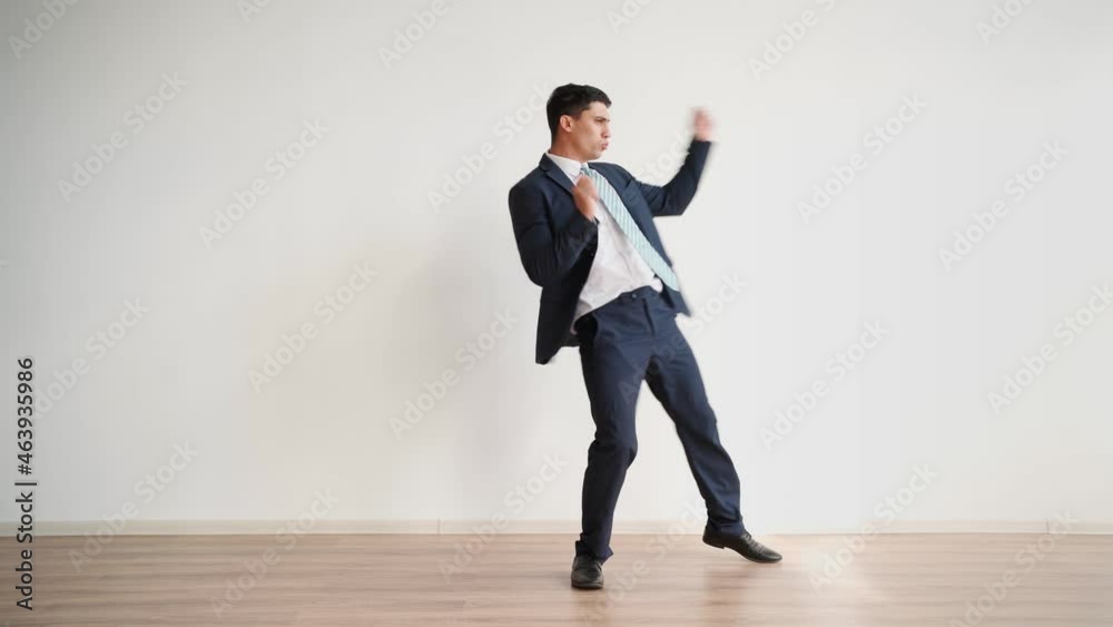 Funny business man dancing for joy and success on a white background. Happy office worker in formal clothes laughs and jumps with victory happiness. Emotions of a winner, career growth.