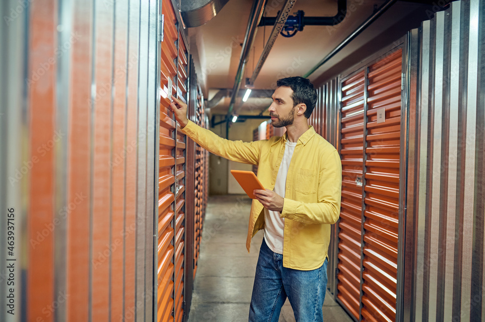 Man touching garage door in storage room