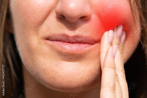 Woman feeling tooth pain with red highlighted area. Woman suffering from toothache or dental illness