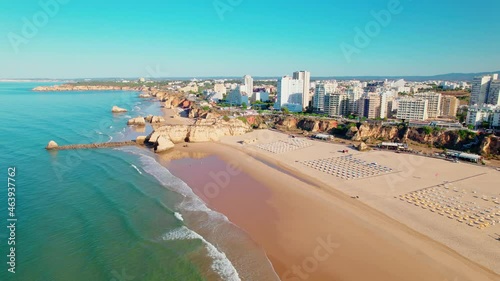 Drone 4K aerial view of Praia da Rocha Beach in Portimão, Algarve, Portugal. Famous luxury holiday hotels and expensive residential areas in Portugal, a coastline with turquoise water and a huge beach
