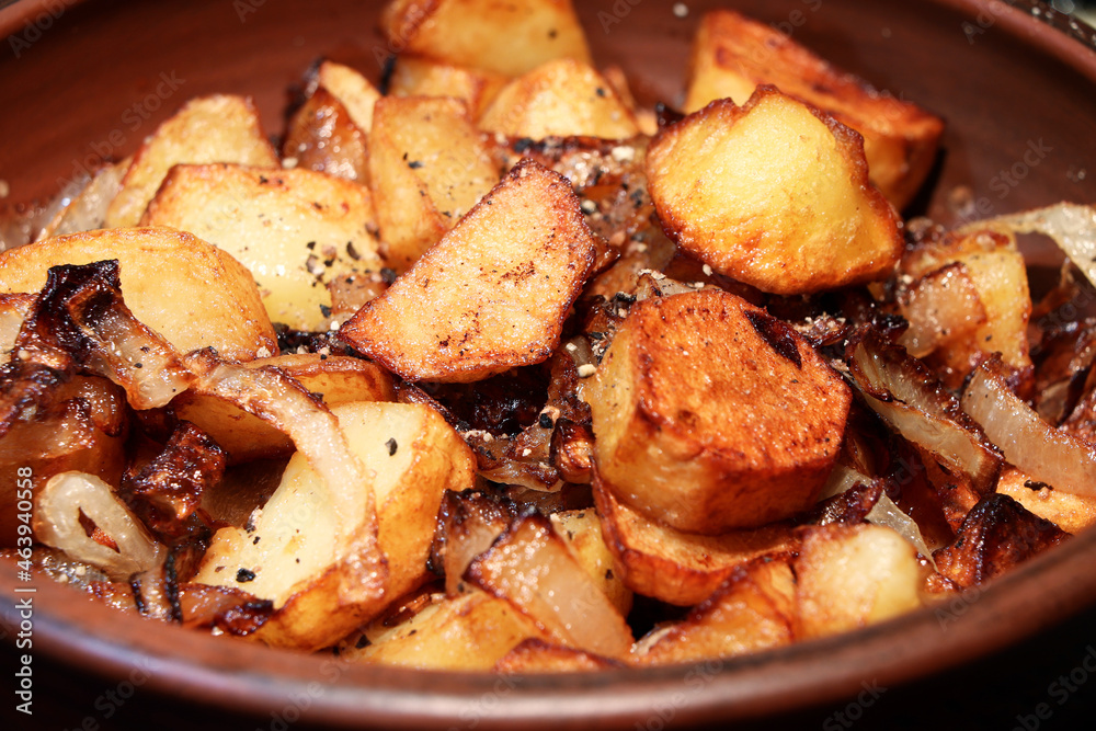 Potatoes with onion on clay plate.Closeup view.Roasted baby potatoes.Fried crispy potatoes. Cooking delicious potatoes fries in hot oil.Unhealthy and oily food. Fast food Potatoes with onion on clay plate.Closeup view.Roasted baby potatoes.Fried crispy potatoes. Cooking delicious potatoes fries in hot oil.Unhealthy and oily food. Fast food