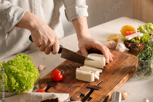 Person slicing fresh feta c...