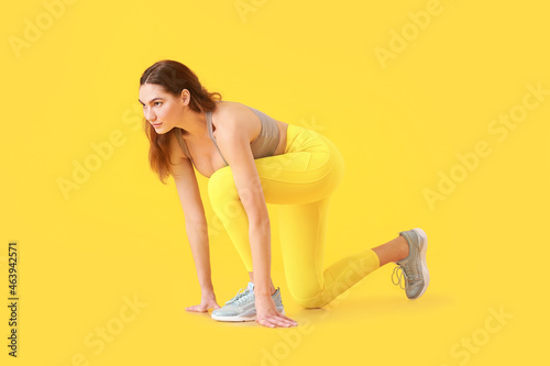 Sporty young woman in crouc...