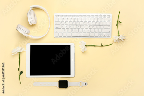 Modern devices with flowers on color background