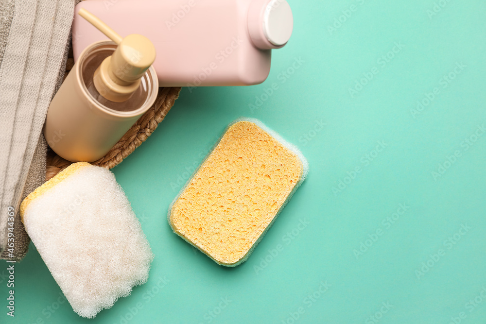 Bath sponges, bottles of cosmetic products and towel on color background Bath sponges, bottles of cosmetic products and towel on color background