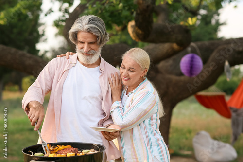 Happy elderly couple cookin...