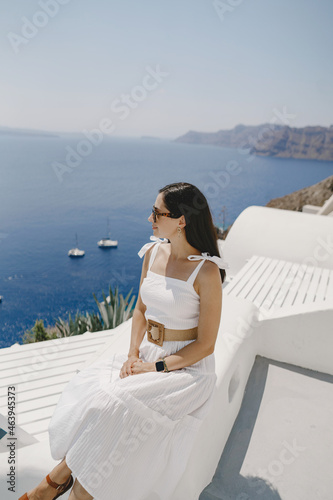 Beautiful young Greek woman in fashion clothes have fun at n the streets of Oia, Santorini, Greece © prostooleh