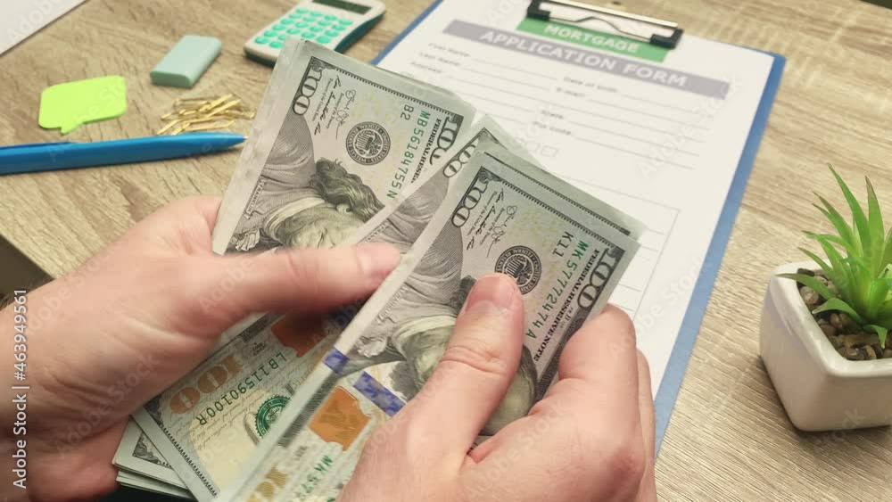 Man counts euros of banknotes received for the payment of a mortgage loan. Man counts euros of banknotes received for the payment of a mortgage loan.