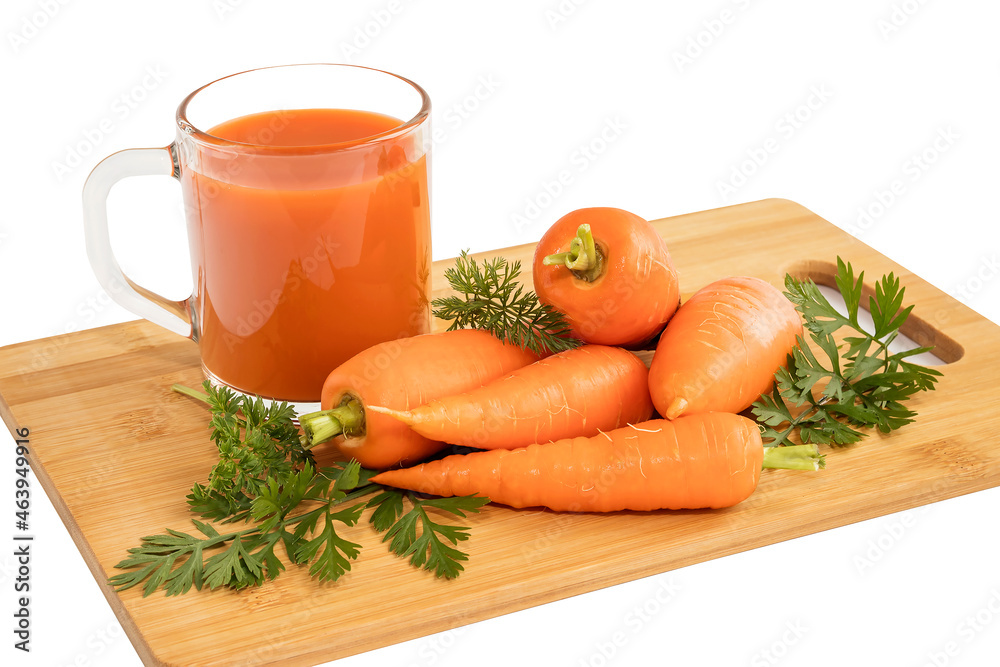 There is a glass cup with healthy vitamin juice on a wooden board and fresh carrots with leaves. There is a glass cup with healthy vitamin juice on a wooden board and fresh carrots with leaves.