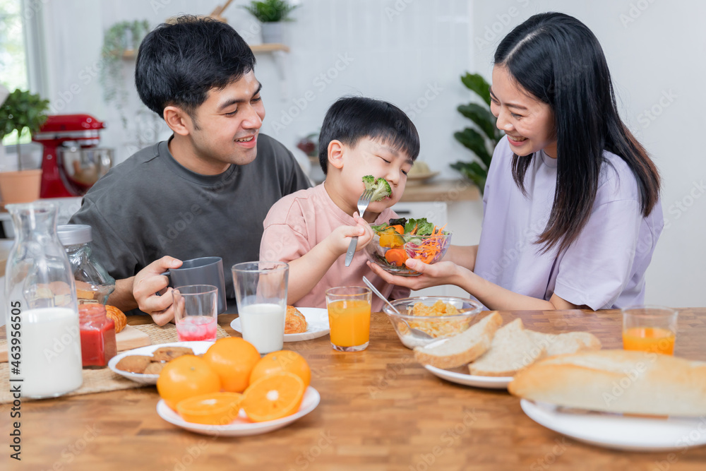 cleaver kid and good boy eating vegetable and drink milk for breakfast with mom during mother diet and eat clean, happy family and healthy son concept cleaver kid and good boy eating vegetable and drink milk for breakfast with mom during mother diet and eat clean, happy family and healthy son concept
