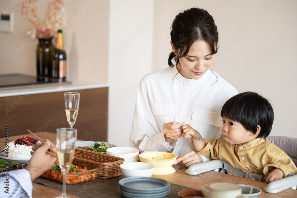 An Asian (Japanese) baby eating his birthday meal with his mom.