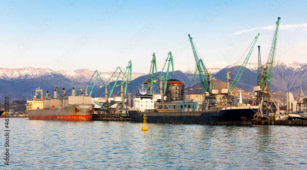 Modern view of cargo terminal mooring line of Batumi Sea Port with cranes loading ships on spring day, Georgia.