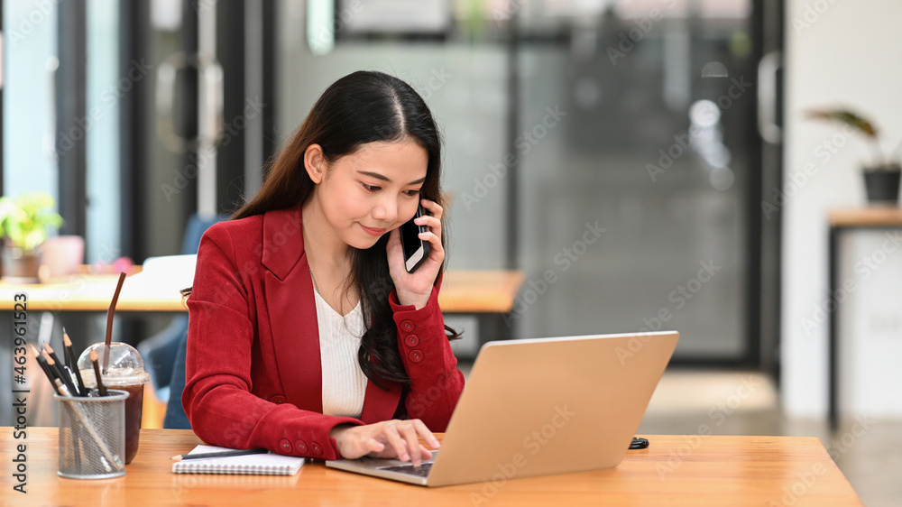 Businesswoman working with computer laptop and talking on mobile phone with with business partner. Businesswoman working with computer laptop and talking on mobile phone with with business partner.