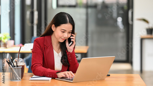 Photography Businesswoman working with computer laptop and talking on mobile phone with with business partner