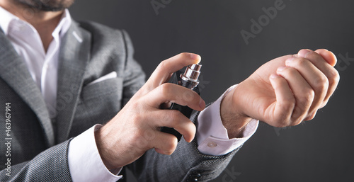 Man spraying perfume in hand.