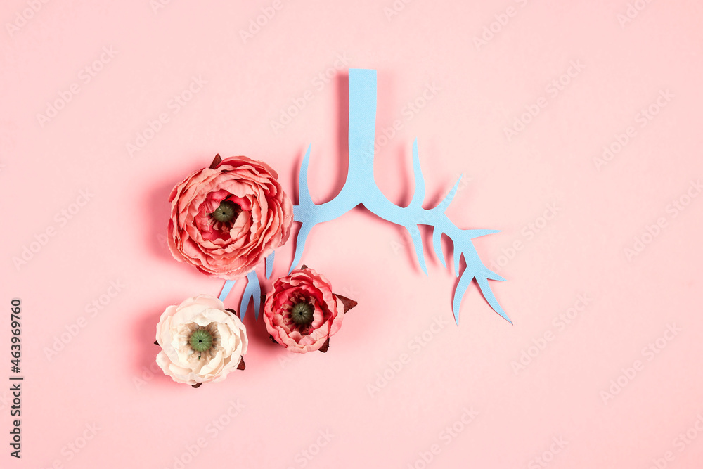 Symbol lungs made of paper and peony flowers on a pink background.