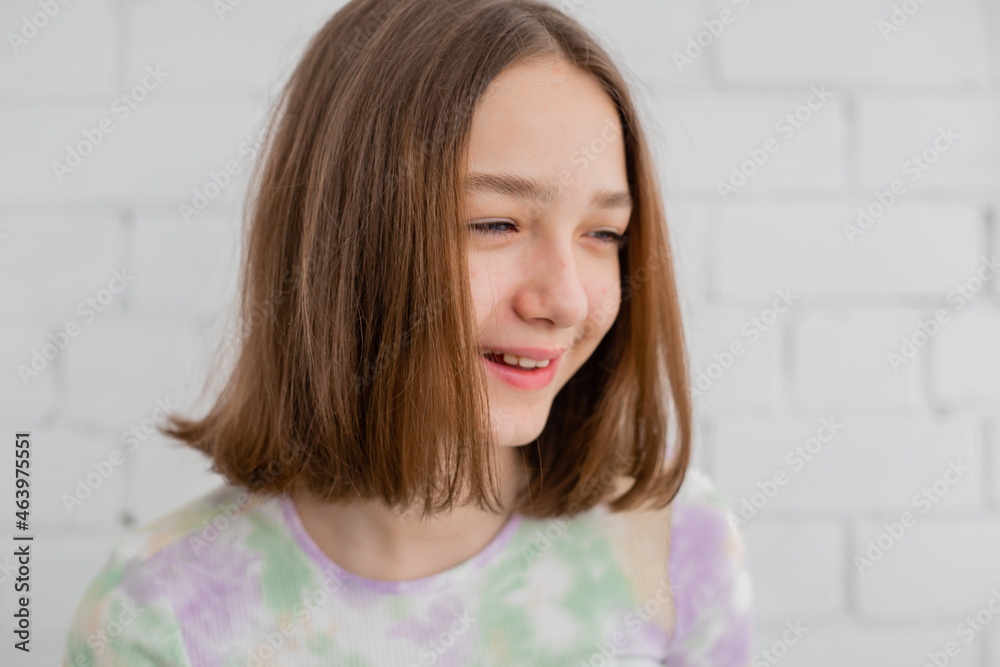 portrait of a slender teenage girl in a light turtleneck in natural light against a white brick wall. natural beauty, no makeup. problematic skin. space for text. High quality photo portrait of a slender teenage girl in a light turtleneck in natural light against a white brick wall. natural beauty, no makeup. problematic skin. space for text. High quality photo