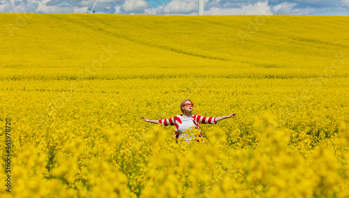 Woman in red and white striped jacket in rapeseed field