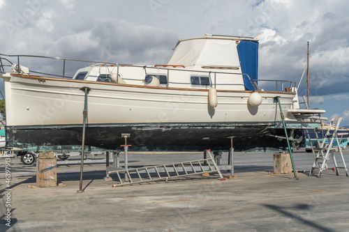 Recreational boat supported on metal tripods for future restoration. S'Estanyol marina, island of Mallorca, Spain