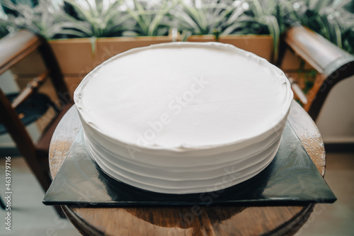 White cake and blank background in greenery outdoor, birthday cake mockup.