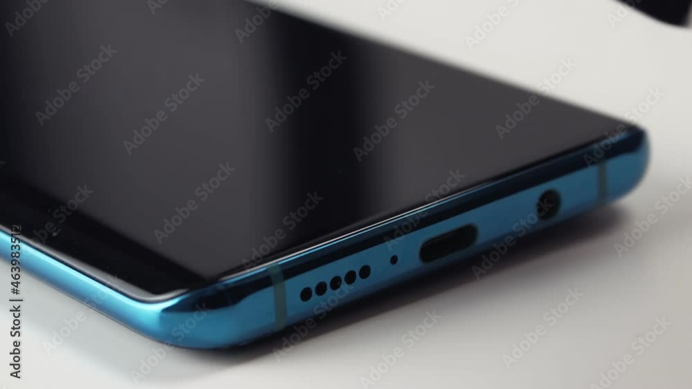 The man gently wipes the mobile phone screen with a brush The man gently wipes the mobile phone screen with a brush