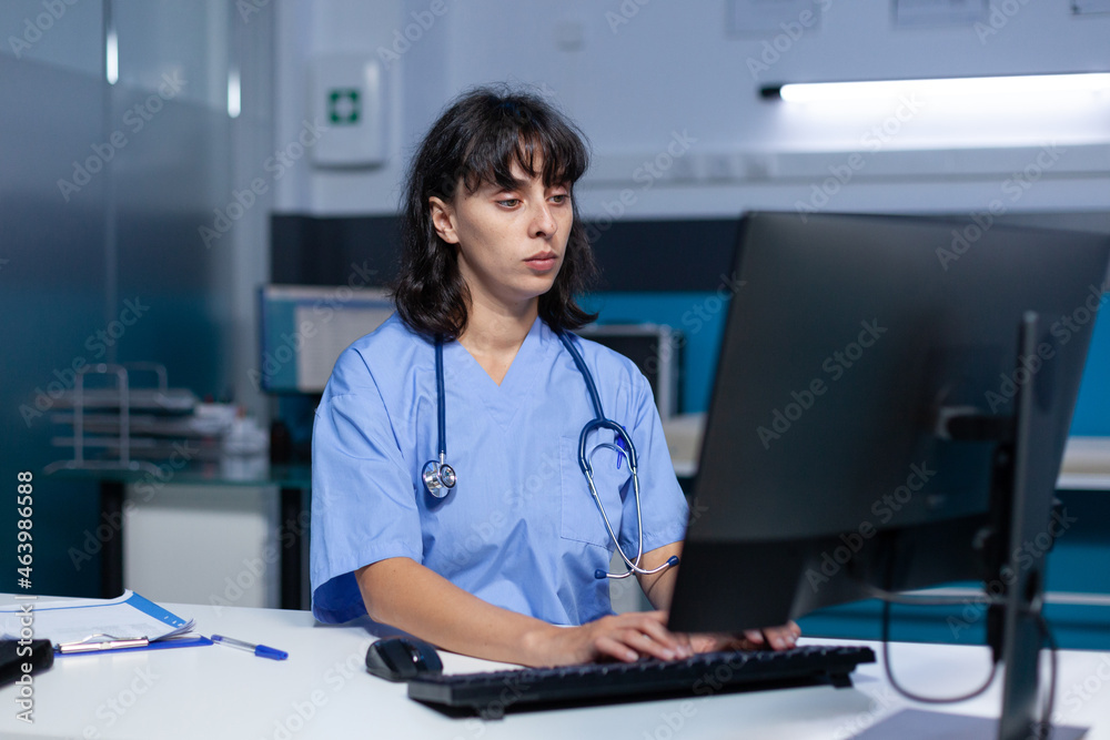 Medical assistant using keyboard and computer at office for healthcare  system. Nurse looking at monitor screen for assistance and support, working  late at night. Specialist with expertise Stock-Foto | Adobe Stock