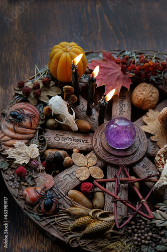 traditional wiccan altar, wheel of the year on abstract dark background. crystal ball, animal skull, pentacle and magic things. witch esoteric ritual for samhain sabbat. autumn season photo