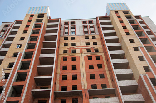 City house under construction. Unfinished multi-storey building. Uncovered facade of the building. Concrete construction is the basis for multi-family housing.