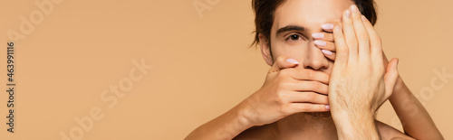 Фотография woman covering face of young man isolated on beige, banner.