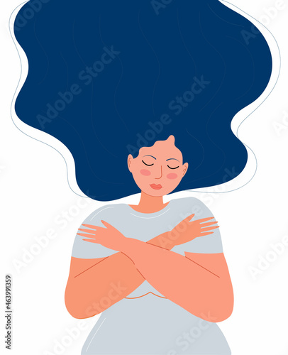 Cute woman with long dark hair hugs herself. Woman is wearing grey dress. Love for yourself, high esteem