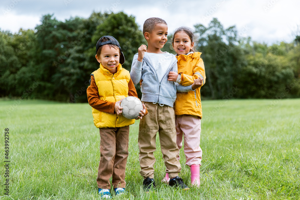 childhood, leisure and people concept - group of happy children with soccer ball at park childhood, leisure and people concept - group of happy children with soccer ball at park