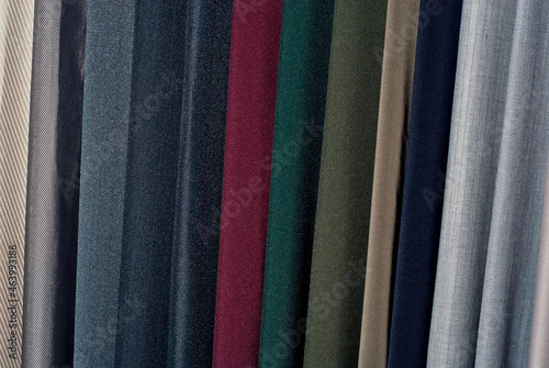 Texture of multicolored fabrics close up. Fabrics for sewing clothes hang in the store. Many fabrics of different materials, colors and textures.
