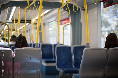 woman behind sitting seat light rail train motion public transport travel explore city commute