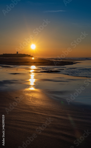 Reflections of the sun on the sand in the early morning. Carcavelos Beach near Lisbon in Portugal.