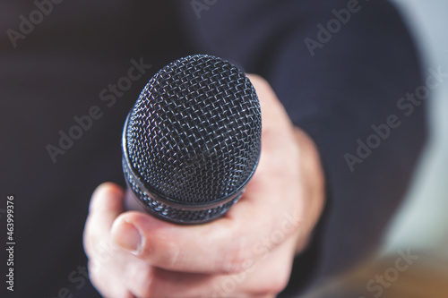 A journalist takes an interview by holding out a microphone. The concept of mass media and the press