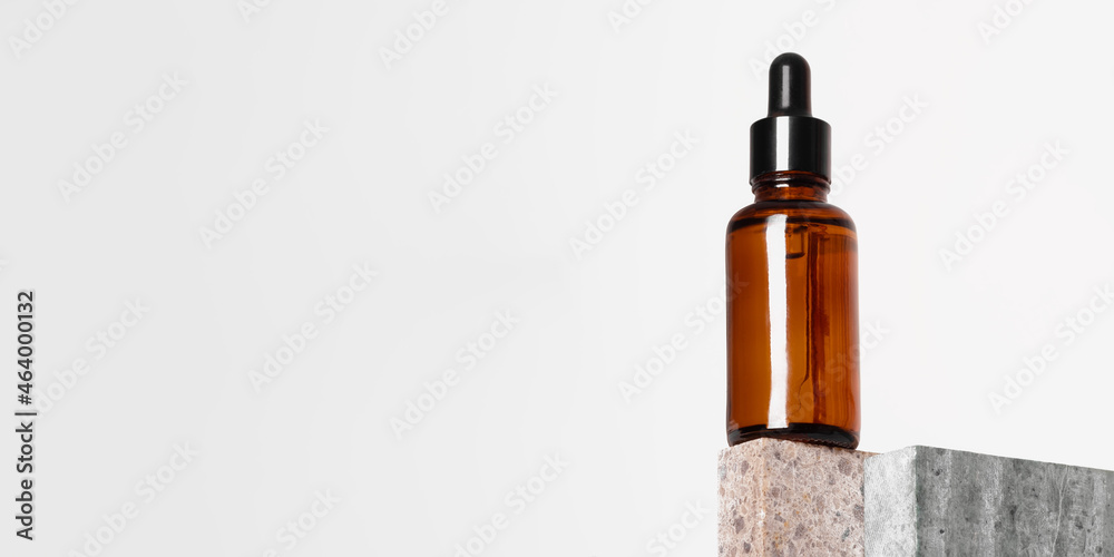 Amber glass dropper bottle with a pipette on a piece of stone. Natural cosmetics concept, natural essential oil. Amber glass dropper bottle with a pipette on a piece of stone. Natural cosmetics concept, natural essential oil.