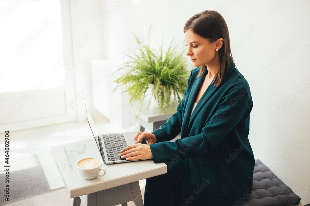 Young woman freelancer working online using her laptop, drinking coffee in a cozy coffeehouse. Young woman freelancer working online using her laptop, drinking coffee in a cozy coffeehouse.