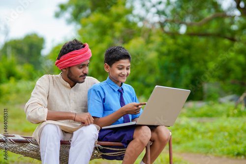 Education concept :cute indian school boy using laptop and giving some information to his father.