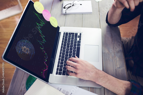 Hands of caucasian businessman sitting at desk, using laptop with statistical data on screen photo