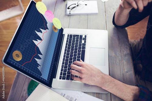 Hands of caucasian businessman sitting at desk, using laptop with statistical data on screen photo