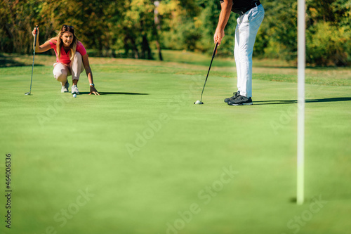 Golf couple putting on the green