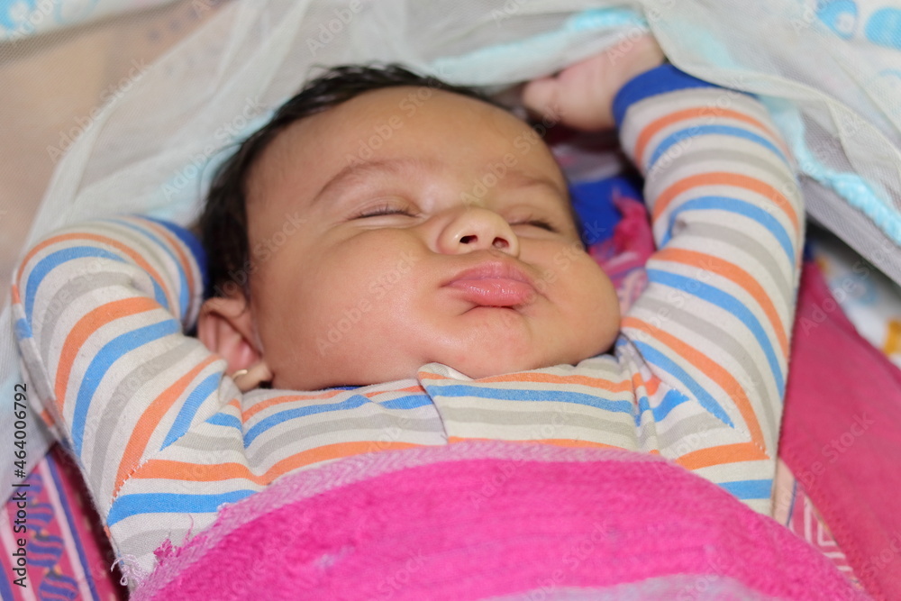 An Indian little newborn innocent baby sleeping in a funny way An Indian little newborn innocent baby sleeping in a funny way