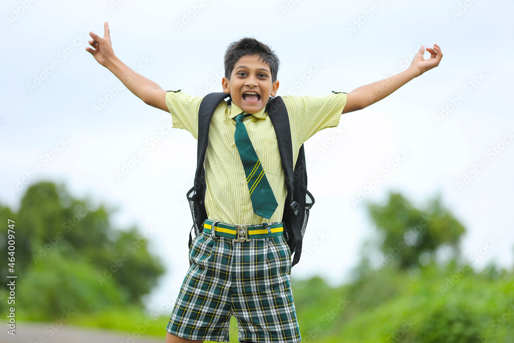 Excited school boy running and jumping on street after school.