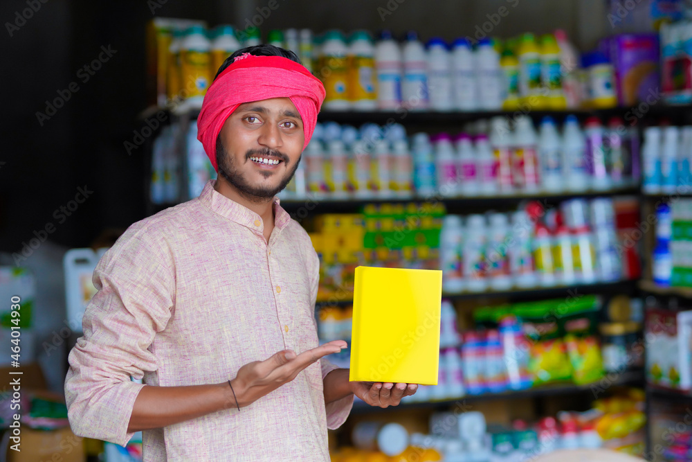 Indian farmer showing fertilizer bag at fertilizer shop.