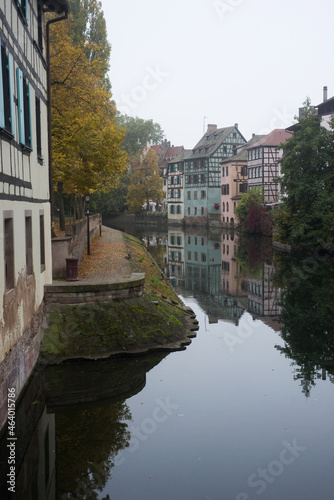 view of autumnal trees in border the Il river at the little france quarter in Strasbourg