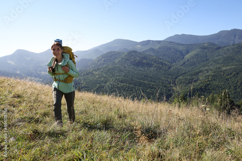 Tourist with backpack walking in mountains on sunny day